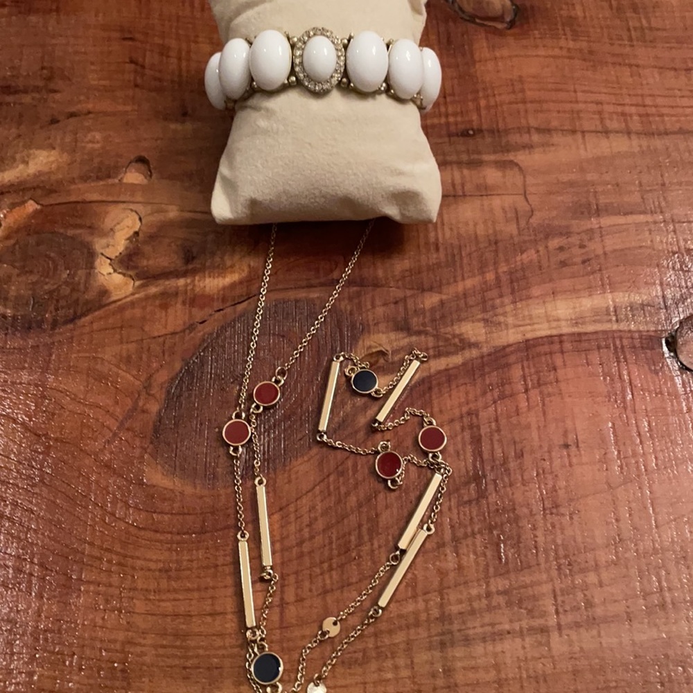 Charming Charlie 34” gold necklace with red and blue discs and white bracelet.